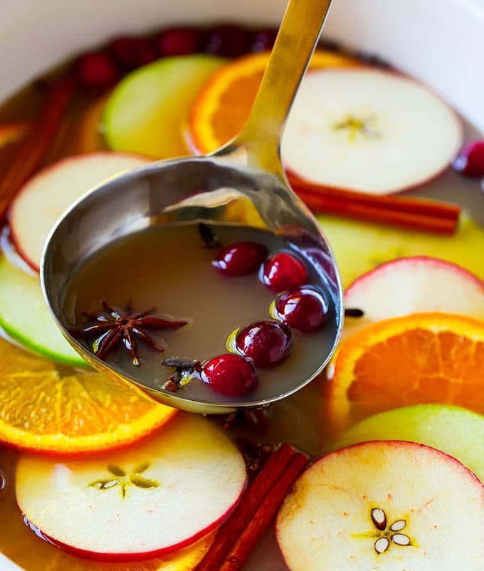 a spoon of liquid with fruit and spices