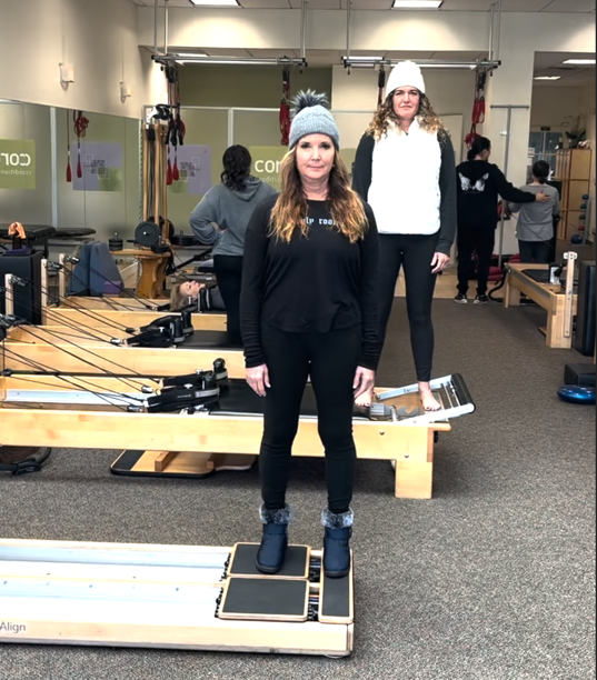 a group of women standing on a platform in a room with equipment