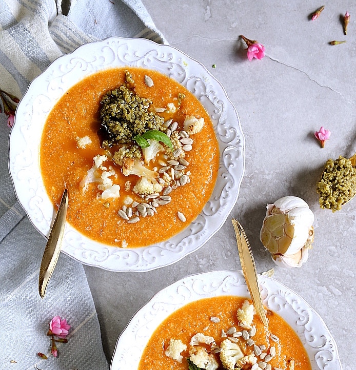 two bowls of soup with spoons and flowers