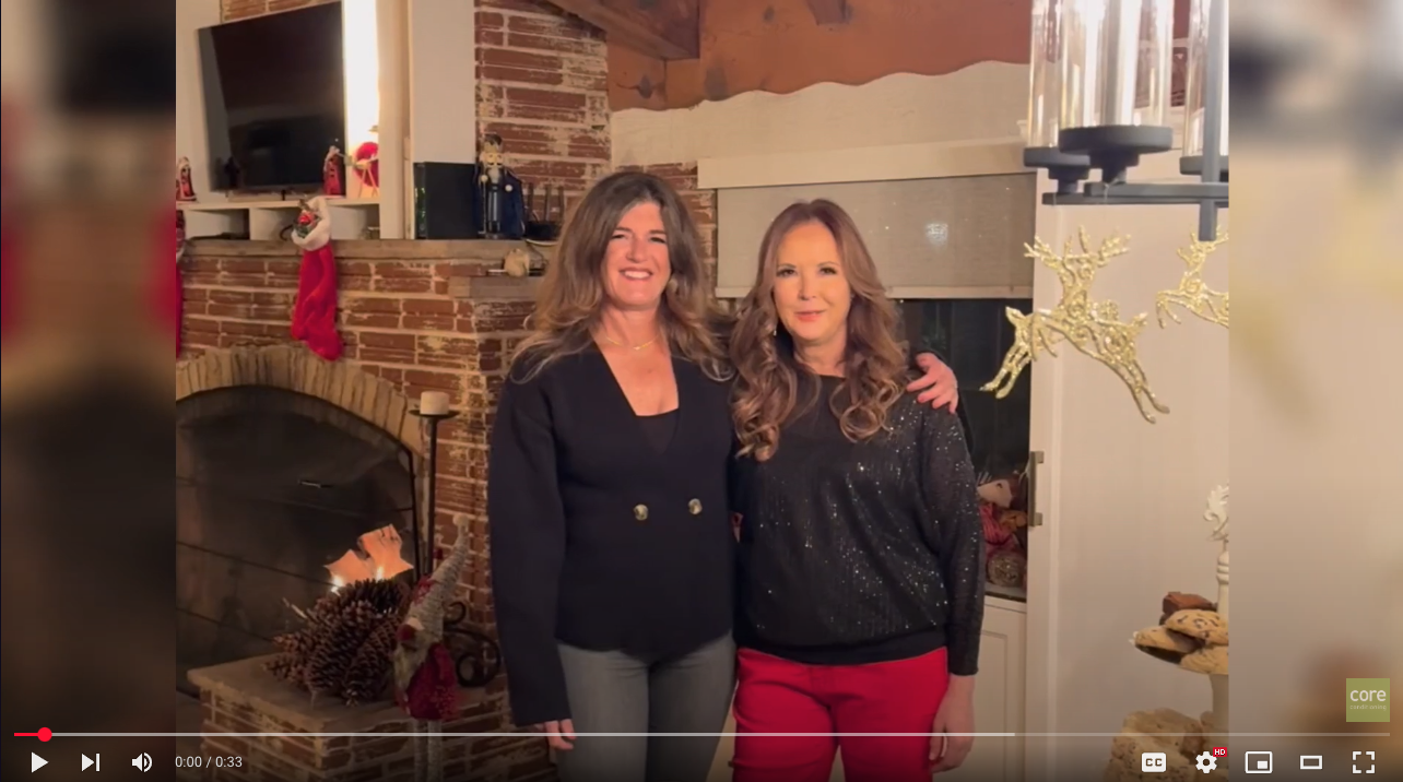 two women standing in front of a fireplace