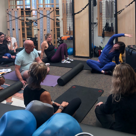a group of people sitting on mats in a room