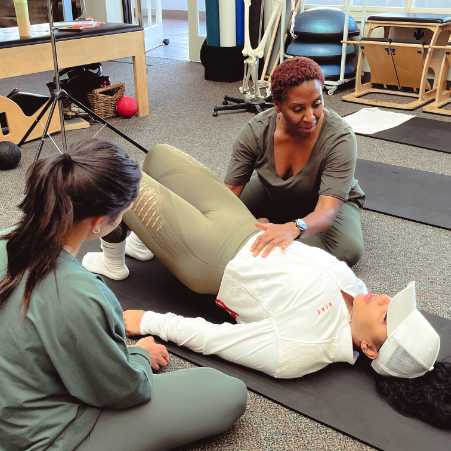 a woman lying on the floor with a woman on her back