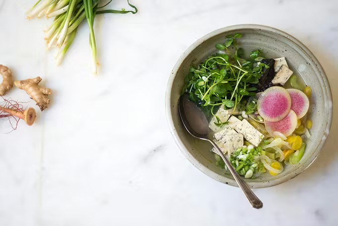 a bowl of soup with vegetables and a spoon