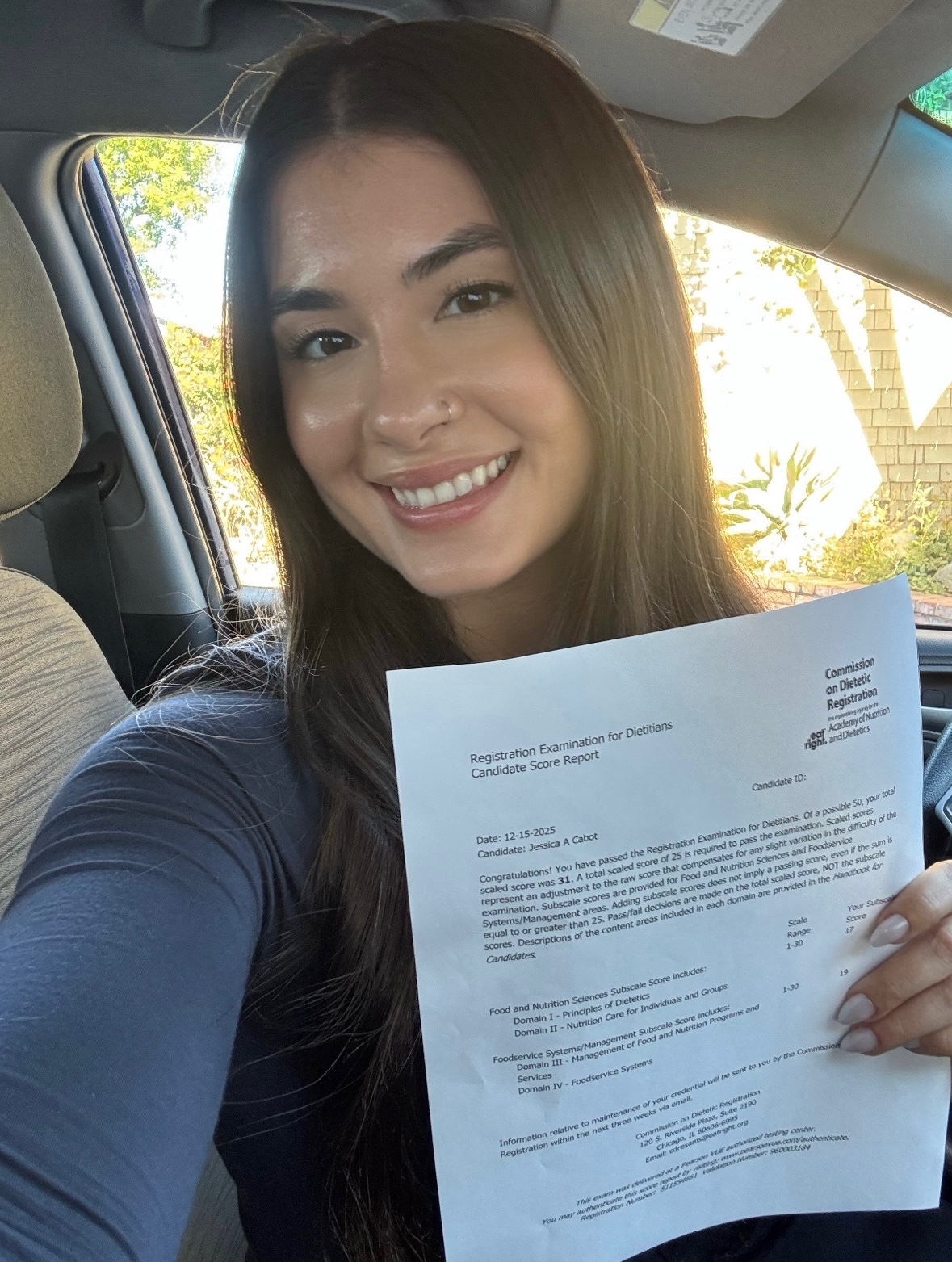 a woman holding a piece of paper in a car