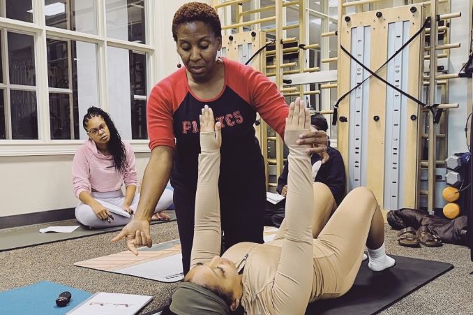 a woman doing a yoga exercise with a group of people