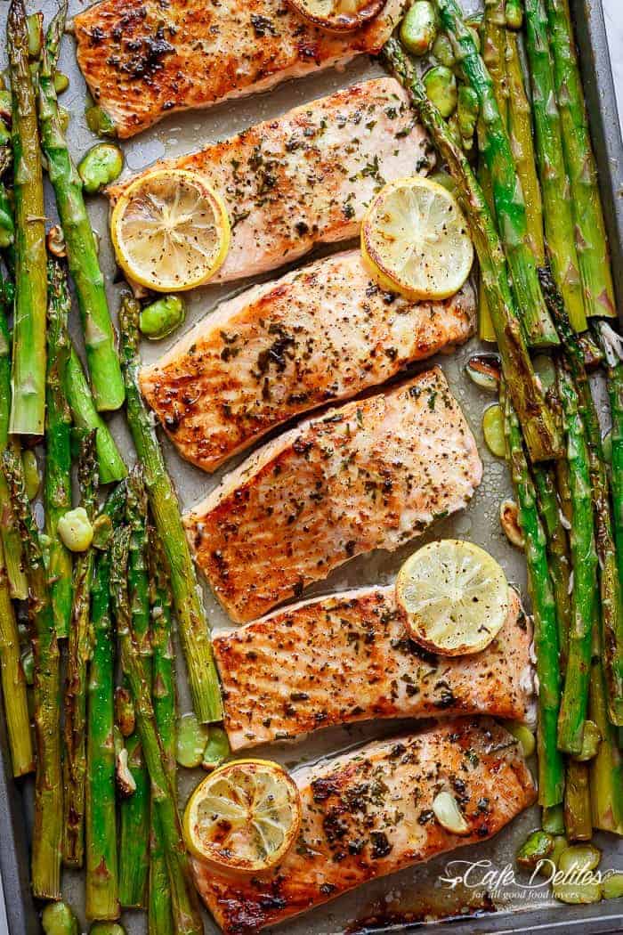 a pan of food with lemon slices and asparagus