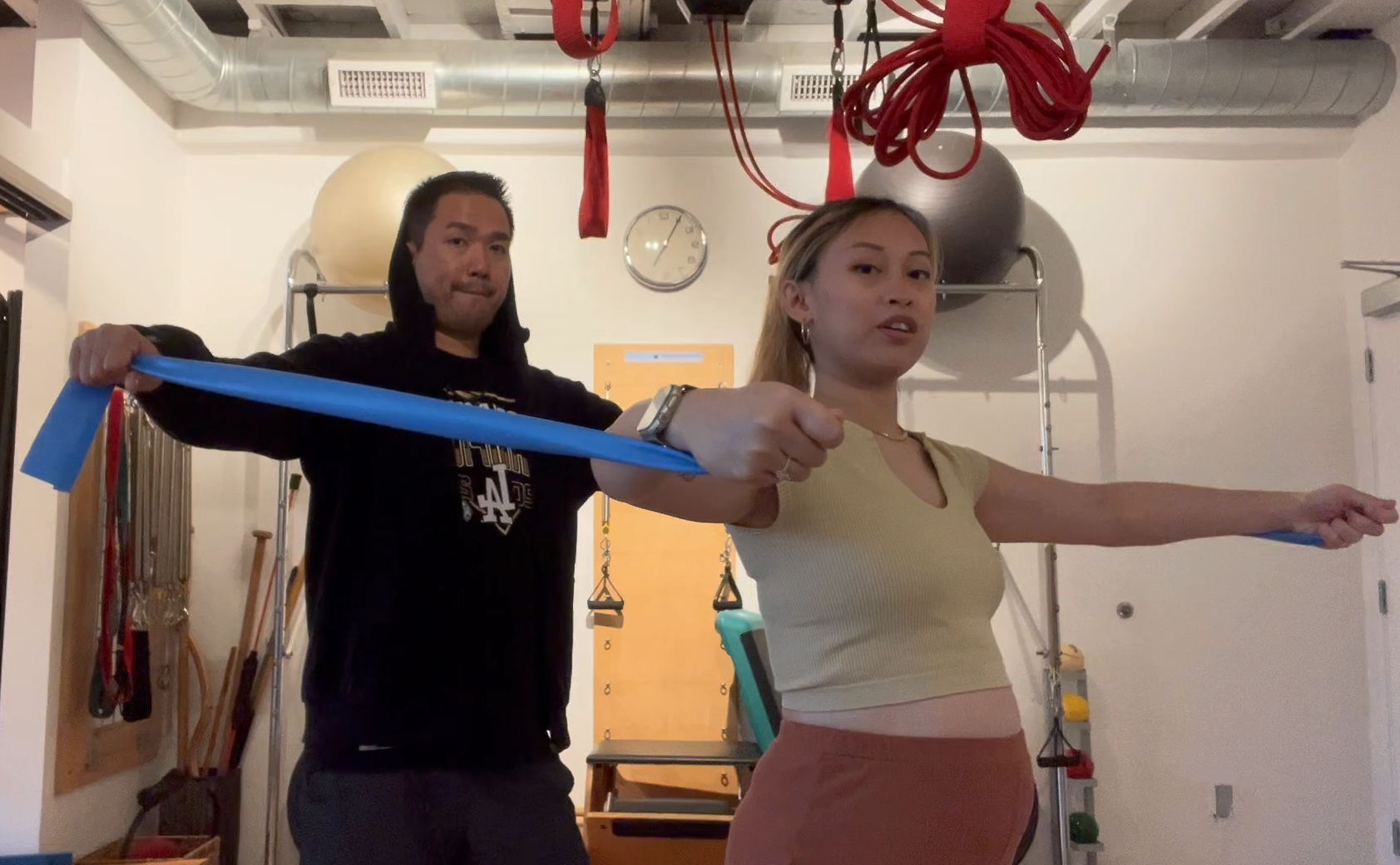a woman holding a blue object with a man behind her