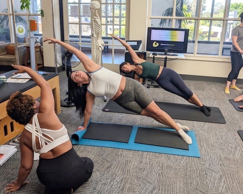 a man helping a woman do a exercise