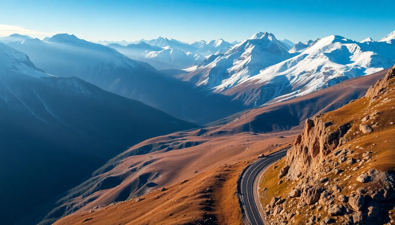 This mesmerizing aerial photograph captures a winding road through a stunning mountain pass, framed by majestic snow-capped peaks. Early morning light adds a serene quality, casting elongated shadows and bringing out cool color tones. The elegant curve of the road draws the eye into the expansive landscape, creating a sense of adventure and tranquility within nature's grandeur.