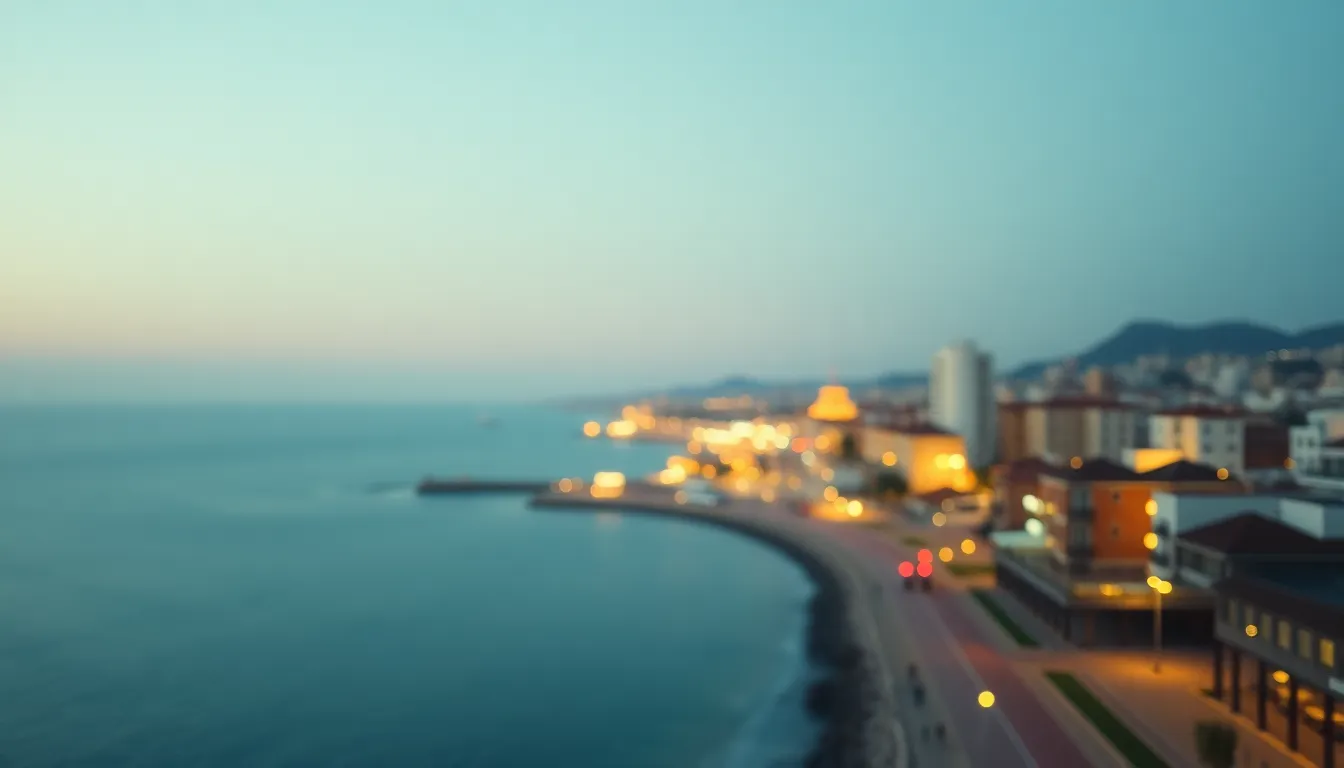 This enchanting aerial view presents a coastal city at twilight, showcasing the tranquil beauty of the waterfront. The soft glow from street lamps illuminates the promenade, adding a warm atmosphere as the city begins to light up for the evening. The composition highlights a sweeping curve of the coastline, where city lights twinkle against the deepening blue sky. Selective focus on the promenade creates a soft bokeh effect, enhancing the magical quality of the scene.