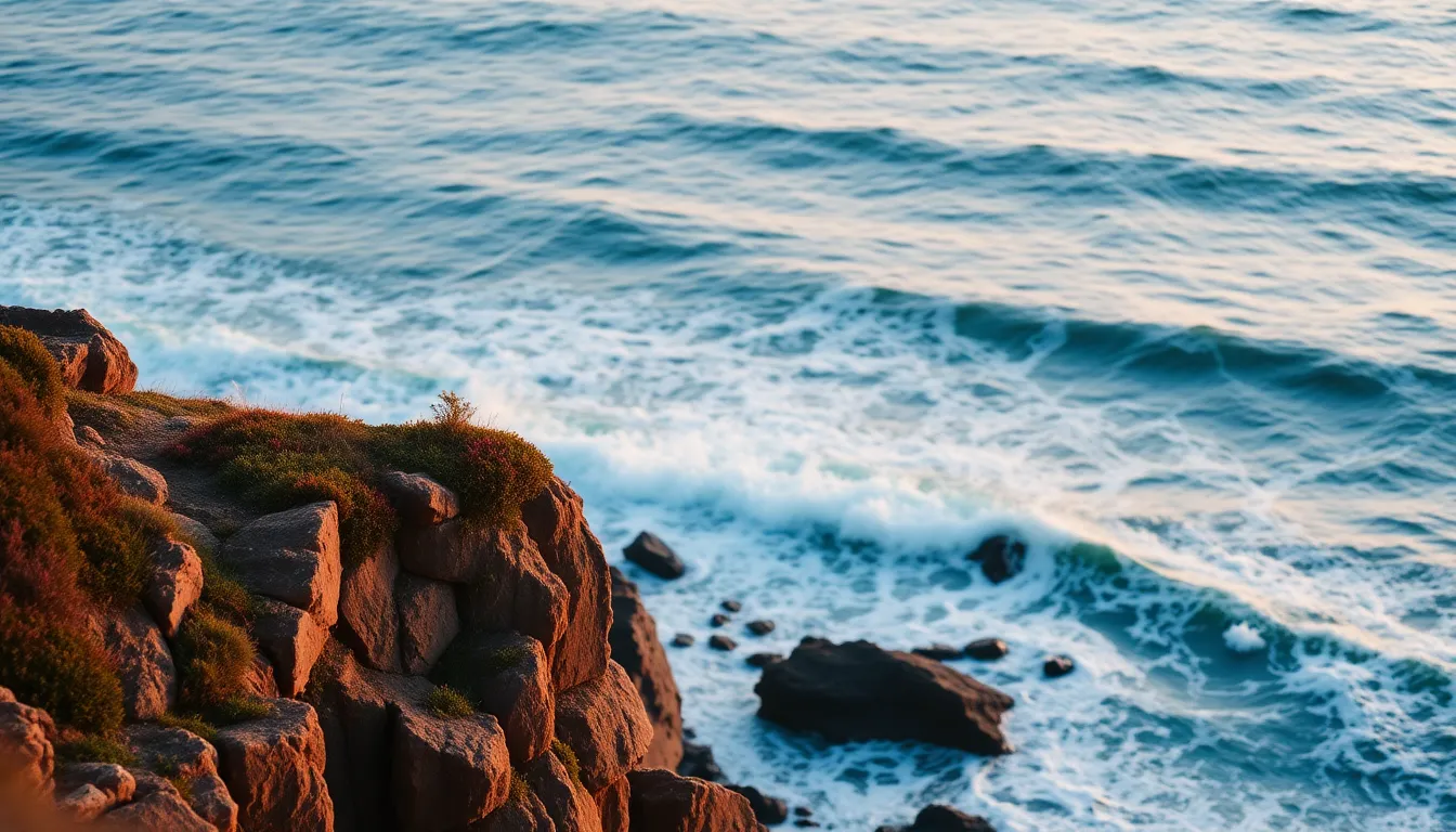 An ethereal aerial view showcases the dramatic beauty of rocky coastal cliffs bathed in the soft light of sunrise. The waves crash energetically against the rocks, creating a dynamic contrast with the serene pastel colors of the sky. Isolated cliffside flora is brought into focus, drawing attention to the rich textures of nature, while the surrounding landscape remains gently blurred. This captivating scene captures the tranquil yet powerful essence of a new day, making it a perfect representation of coastal beauty.