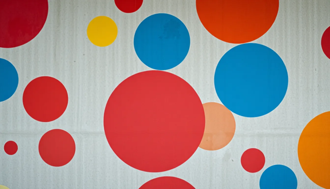 This dynamic image showcases an abstract representation of vibrant painted circles on a concrete wall. The studio lighting accentuates the texture of the wall and the paint, creating an engaging visual experience. A shallow depth of field allows the bright colors to stand out against a soft background, enhancing the playful energy of the composition. Centered symmetry in the arrangement of shapes provides a harmonious balance, inviting viewers to explore the vibrant interaction of color and form.
