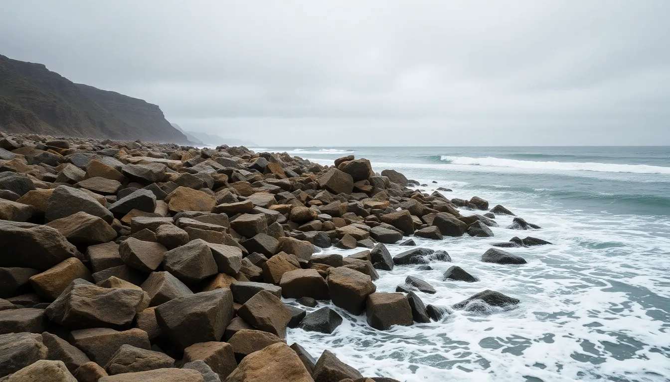This evocative photograph presents a rugged rocky coastline under a blanket of gray overcast skies. The turbulent waves crash against the stones, capturing the raw power of nature. Muted earth tones and the soft lighting amplify the dramatic mood of the scene, while the sharp details highlight the textures of the rocks and water. This image embodies the fierce beauty and solitude often found on remote islands.