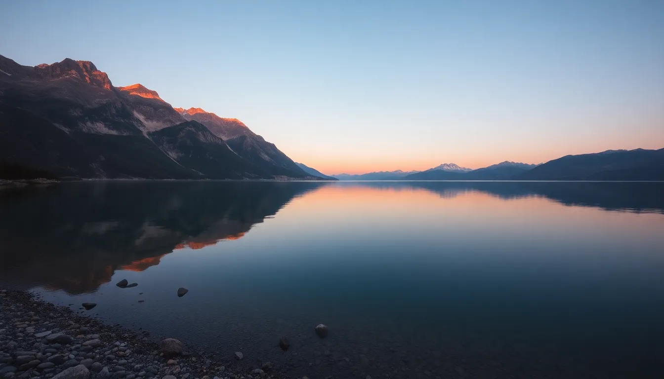 In this breathtaking panoramic image, a tranquil mountain lake captures the serene reflections of towering peaks against a backdrop of dusky twilight. The soft fading light casts warm hues over the landscape, evoking a sense of calm and peace. The pristine water mirrors the rugged mountain surfaces, creating a harmonious balance between nature’s elements. This scene invites viewers to immerse themselves in the peaceful essence of a mountain retreat at dusk.