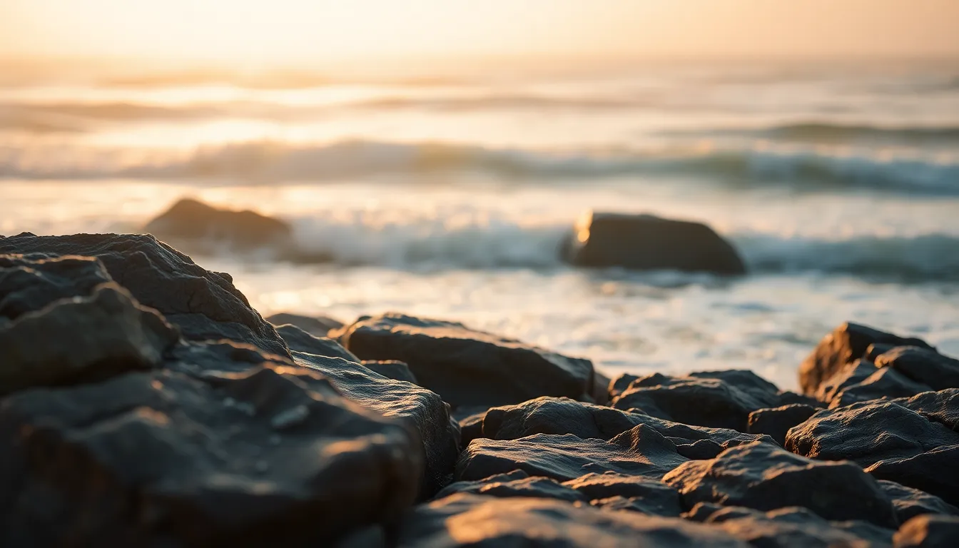 This serene image captures the tranquility of the ocean at dawn, with soft waves brushing against rocky shores. Early morning light creates a warm atmosphere shrouded in mist, enhancing the peaceful mood. Textures of the weathered rocks contrast beautifully with the glistening water, while the soft color palette adds to the calm feeling of the scene.